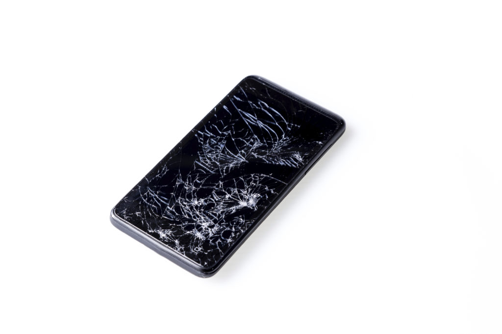 Closeup of mobile smartphone with broken screen isolated on white.